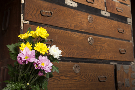Chrysanthemum flowers in front of japanese antique chestの写真素材