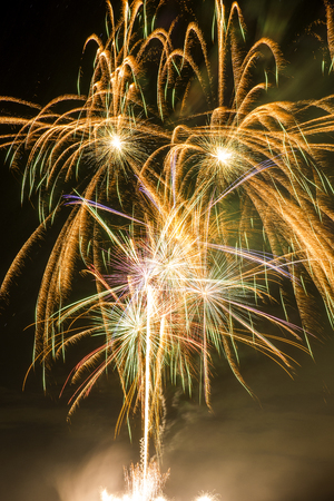 Flow of orange fireworks from shot up to burstingの写真素材
