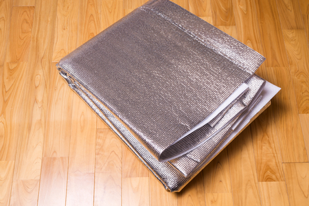Folded aluminum foil bubble heat insulation sheet on a wood floor
