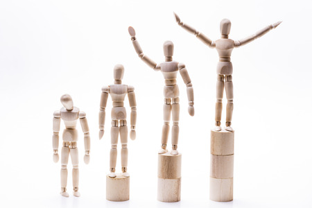 Front facing wooden dolls lined rank order in front of white background