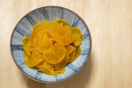 Yellow pickled radish Takuan served in a small bowlの写真素材