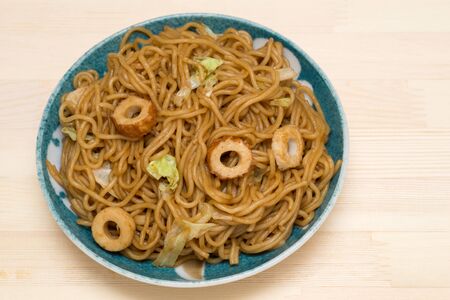 Japanese fried noodles with fish stick on a pottery plateの写真素材