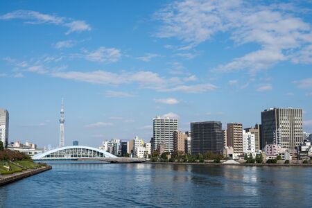 Bridge over the river and riverside building under blue sky in Tokyo