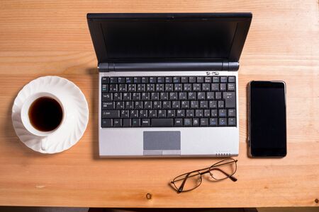 Laptop computer and smartphone on a wooden desk