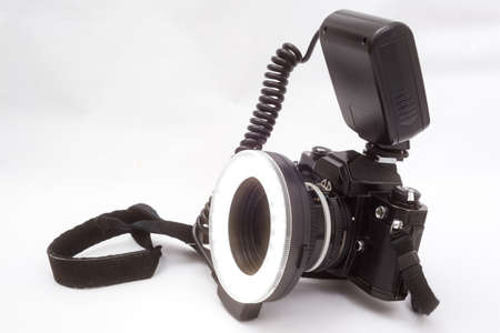 LED ring light attached to a film camera in front of light gray backgroundの写真素材