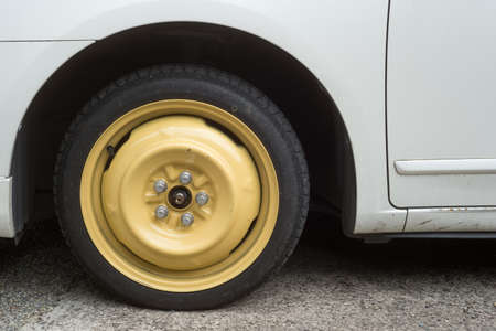 White car with yellow wheel first aid tire