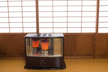 Burning kerosene heater in front of wooden sliding door with shoji screensの写真素材