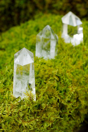 Hexagonal quartz crystal stone in front of blurry crystal stones in vertical compositionの写真素材