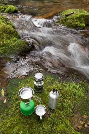 Outdoor equipment on a green moss beside brook in vertical compositionの写真素材