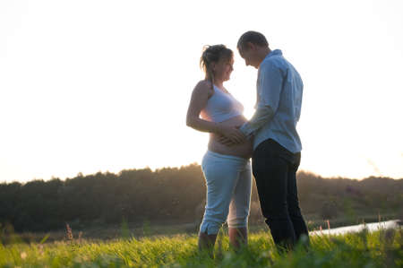 pregnant wife with her husband outdoorの写真素材