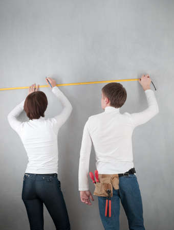 couple measuring wall for home redecoratingの写真素材