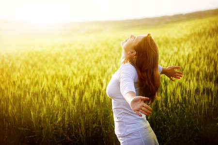young woman in green wheat fieldの写真素材