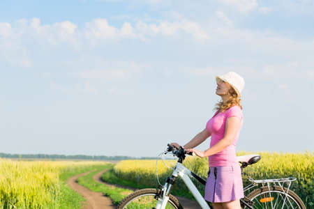 woman cycling countryside in summerの写真素材