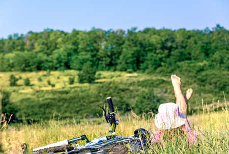 woman cycling countryside in summer retro の写真素材
