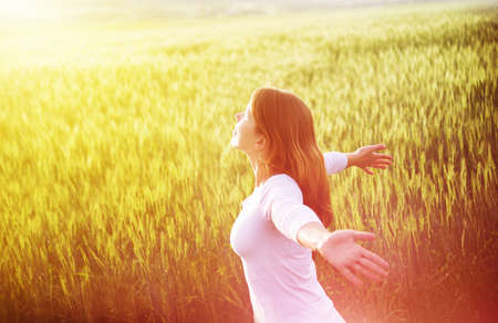 young woman in green wheat fieldの写真素材
