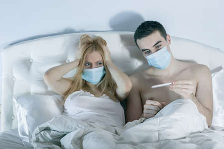 couple in bed suffering common coldの写真素材