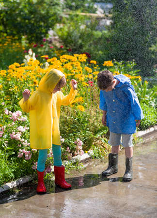 kids in rain at backyardの写真素材