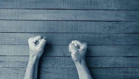 man fists on a wooden tableの写真素材