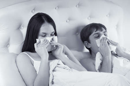 couple in bed suffering common coldの写真素材