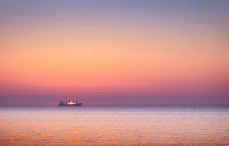 landscape with boat in the sea at sunsetの写真素材
