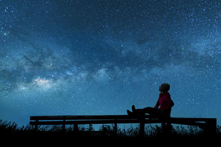 Girl watching the stars in night skyの写真素材