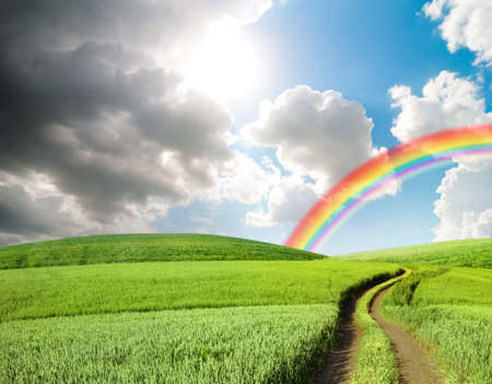 dark stormy clouds and sun with rainbow, moody weather landscapeの写真素材