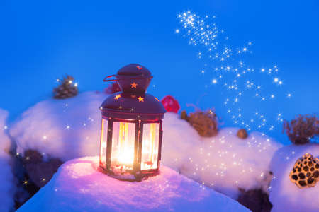 lantern with candle on snow christmas backgroundの写真素材