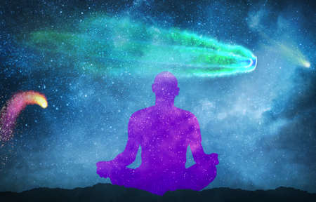 silhouette of man practicing meditation outdoors in night under starry sky