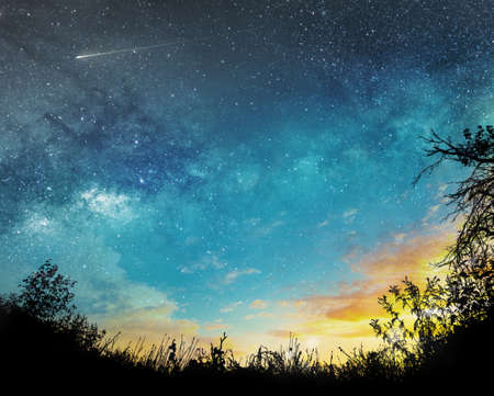 sunset to night sky background with stars, comet and cloudsの写真素材