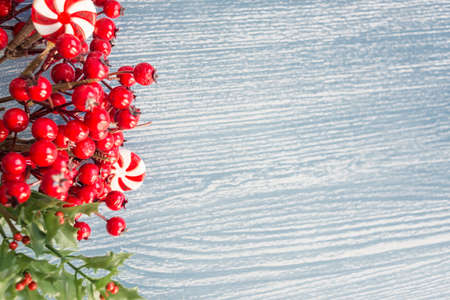 christmas  background with wreath of red holly on wooden floorの写真素材