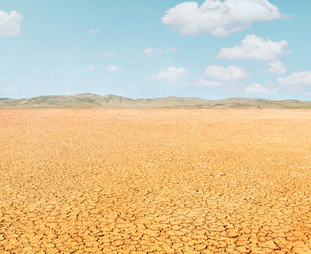 dry cracked dirt in desert landscape in Africaの写真素材