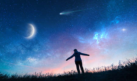 silhouette of girl watching the stars in night skyの写真素材