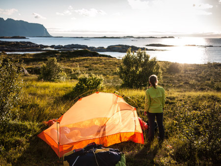 woman camping with tent near seaside in Norwayの写真素材