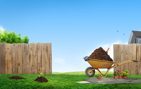work in garden backyard lawn with tools, background with wooden fence and houseの写真素材