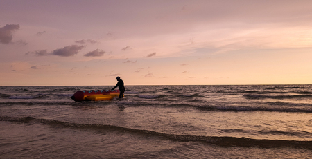 Beautiful sunset or sunrise of the sea with Rubber boat and trainer on purple and vanilla sky background,lonely and landscape concept,design for illustration,travel and advertising.の写真素材