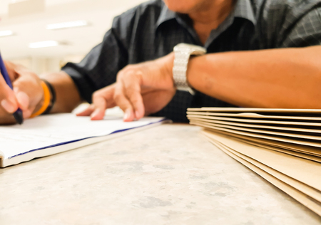 Brown Paper bag on desk with Blur Male office workers writing something in notepad,business and Education concept,design for illustration.の写真素材