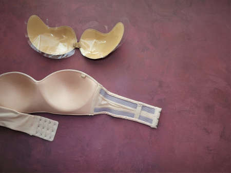 bras without straps on a burgundy background close-up. High quality photoの写真素材