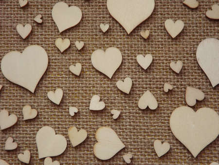 wooden hearts of different sizes on jute fabric as a Valentines day greeting card. High quality...