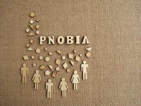 mental illness-phobia in the form of wooden letters and figures of people on a jute background. High...
