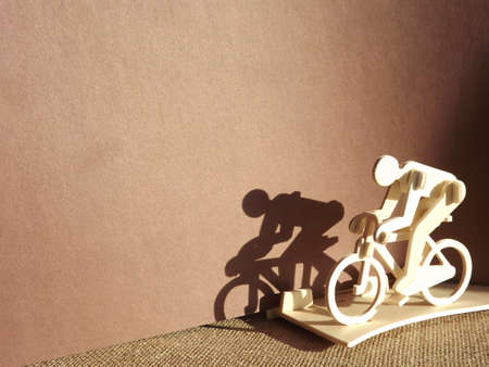 cyclist on a bicycle made of wood on a brown background.