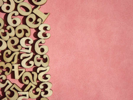 wooden numbers are randomly arranged on pink suede. High quality photoの写真素材