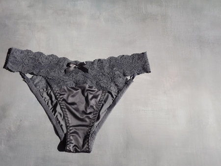 Dark blue sexy panties made of silk and guipure on a gray background. High quality photoの写真素材