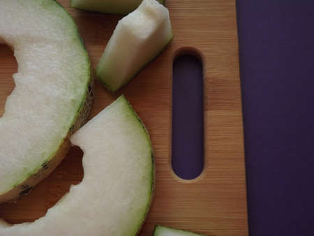 ripe melon cut into slices on a wooden board. High quality photo