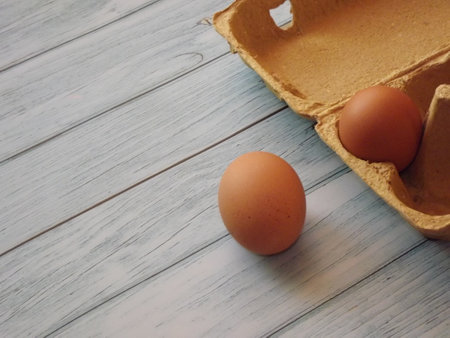 chicken eggs in an egg box on wooden background. high quality photoの写真素材