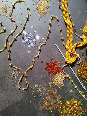 The process of crocheting from beads and sequins of golden color. Making a dress for a merry Christmas. High quality photoの写真素材