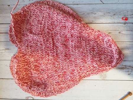 The process of knitting and crocheting pillows in the shape of a pink heart. High quality photo