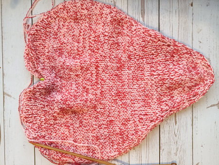 The process of knitting and crocheting pillows in the shape of a pink heart. High quality photo