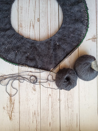 The process of knitting a jumper made of gray wool. High quality photo