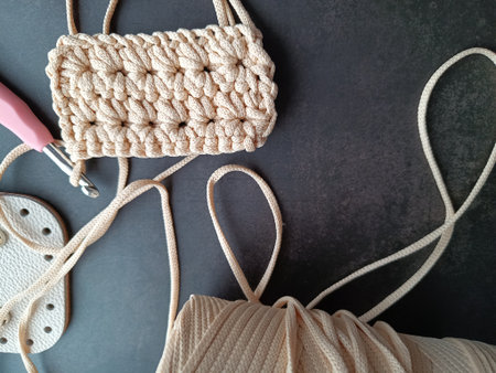 The process of crocheting a handbag made of cord and leather accessories. High quality photo