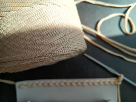 The process of crocheting a handbag made of cord and leather accessories. High quality photo